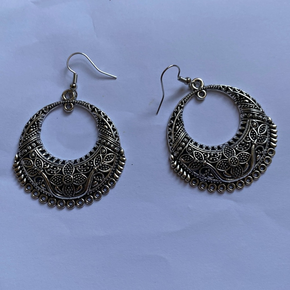 Intricate silver tone earrings. Sanitized and in as new condition.